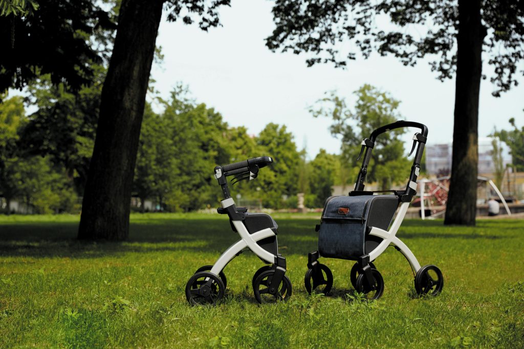 Two modern rollators on a grassy park in summer.